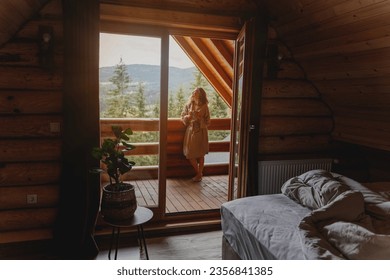 Young relaxed cheerful woman enjoying the morning and nature on the cottage balcony at sunrise with a cup of tea - Powered by Shutterstock