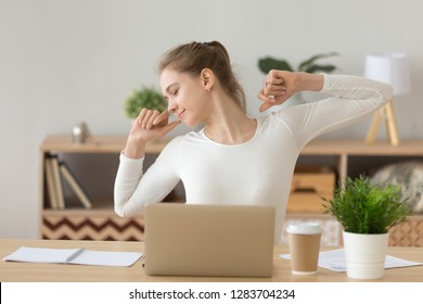 Young relaxed woman feeling no stress stretching sitting at desk with laptop satisfied with study job well done, happy freelancer enjoys distance online work at home workplace taking break for rest