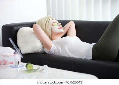 Young Relaxing Woman Applying Facial Mask At Home
