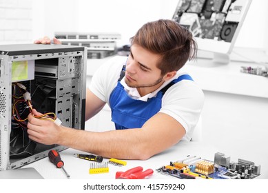 Young Repairer Disassembling A Computer Internal Parts In Service Center