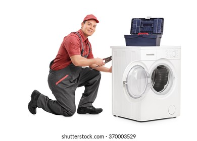 Young Repairman Fixing A Washing Machine And Looking At The Camera Isolated On White Background