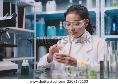 Young researcher is grind the powdered research into grinding cup in the laboratory. women are happy to test cosmetics or medicine for beautiful skin care.