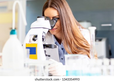 Young researcher looking at microscope in laboratory - Shutterstock ID 1343354993