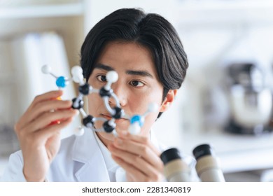 Young researchers looking at molecular models. - Powered by Shutterstock