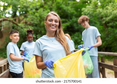 Young Responsible People Doing Community Charity Work In The Park. Group Of People, Cleaning Together In Public Park, Saving The Environment.