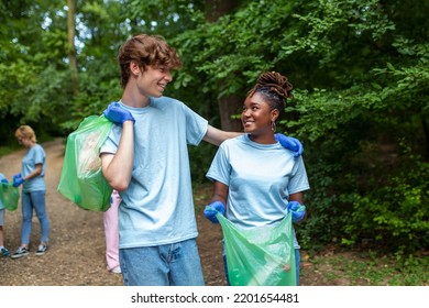 Young Responsible People Doing Community Charity Work In The Park. Group Of People, Cleaning Together In Public Park, Saving The Environment.