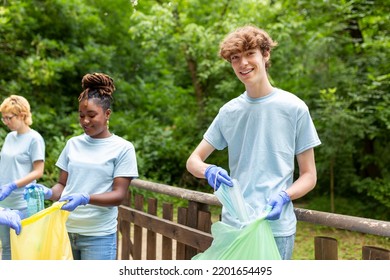 Young Responsible People Doing Community Charity Work In The Park. Group Of People, Cleaning Together In Public Park, Saving The Environment.