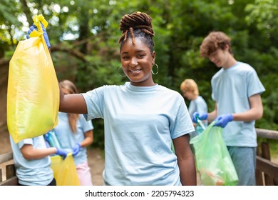 Young Responsible People Doing Community Charity Work In The Park. Group Of People, Cleaning Together In Public Park, Saving The Environment.