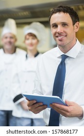 Young restaurant manager holding his tablet  smiling at the camera 