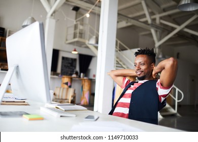 Young Restful Manager Sitting By Desk In Front Of Computer Monitor And Watching Webcast In Office