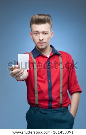 young retro man holding empty card over blue background