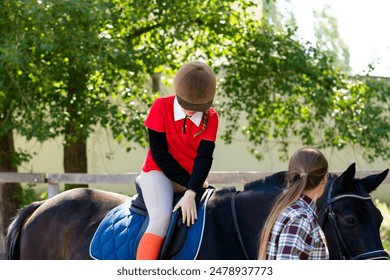 Young rider adjusts helmet on horseback under trees. Riding school - Powered by Shutterstock