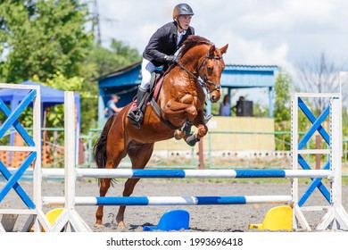 Young Rider Man Jumping On His Horse Over The Barrier On Show Jumping Equestrian Competition