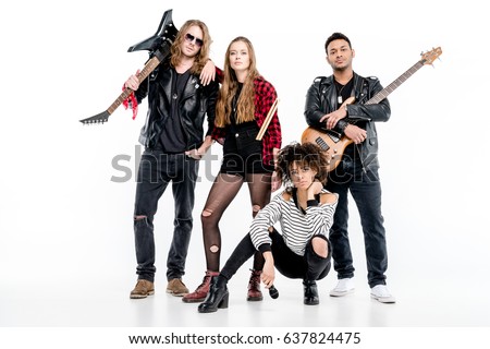 Young rock and roll band standing with microphone, drumsticks and guitars isolated on white 