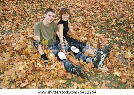 young roller couple sit on yellow leaves