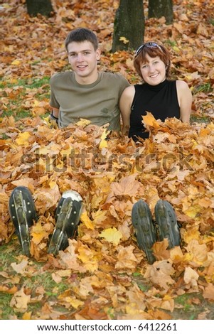 young roller couple sit in yellow leaves