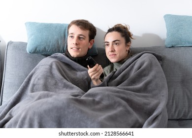 Young Romantic Couple Covered With A Blanket Channel Surfing