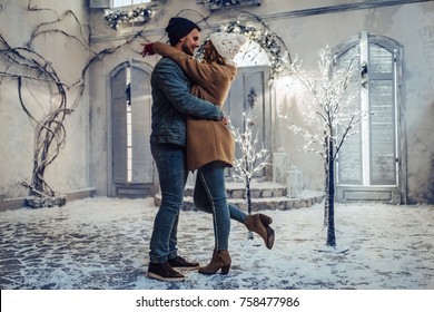 Young romantic couple is having fun outdoors in winter before Christmas. Enjoying spending time together in New Year Eve. Two lovers are hugging and kissing in Saint Valentine's Day. - Powered by Shutterstock