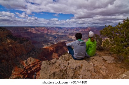Young romantic couple sitting with an amazing view of the Grand Canyon Arizona USA