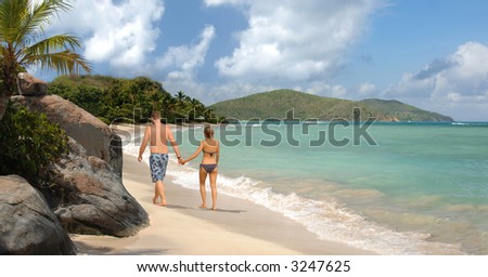 Young romantic couple walking along a tropical beach