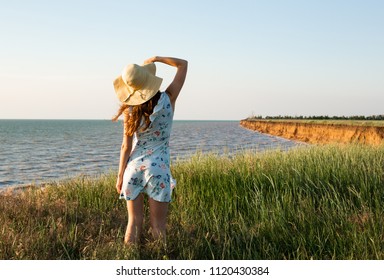 Young Romantic Woman in Blue Dress and Hat on  Background Sea at The Sunset. Seating Back to Camera. A Girl with Red  Hair. Summer Time - Shutterstock ID 1120430384