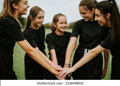 Young rugby players stacking hands together - Powered by Shutterstock