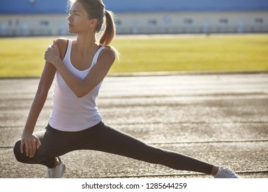 Young Runner Fit Woman Streching Before Exercises Outdoors. Athletic Female Strech After Workout Outside. Sport And People Concept.