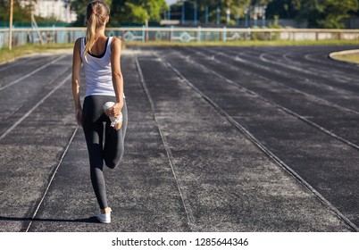 Young Runner Fit Woman Streching Before Exercises Outdoors. Athletic Female Strech After Workout Outside. Sport And People Concept.