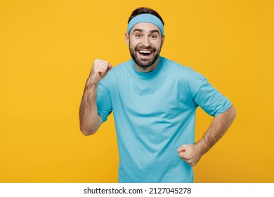 Young Runner Fitness Trainer Instructor Sporty Man Sportsman In Headband Blue T-shirt Spend Weekend In Home Gym Do Winner Gesture Isolated On Plain Yellow Background. Workout Sport Motivation Concept