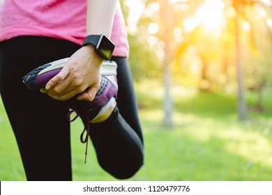 Young runner woman stretching leg before run in park. Close up athletic girl wear running shoes, smart watch warm up outdoor. Sport activity tracker watch at wrist to monitor heart rate during cardio - Powered by Shutterstock