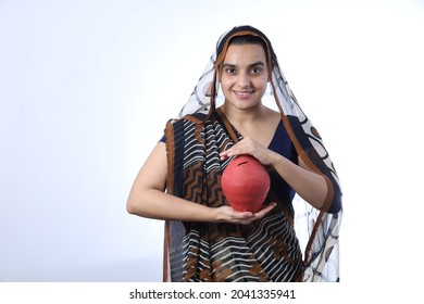 Young Rural Indian Bald Widow Saving Money Holding A Piggy Bank And Wearing A Saree Portraying Various Expressions Of The Widow Life. She Is Confident And Portraying Savings Concept.