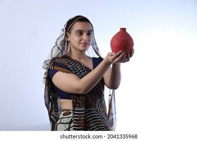 Young Rural Indian Bald Widow Saving Money Holding A Piggy Bank And Wearing A Saree Portraying Various Expressions Of The Widow Life. She Is Confident And Portraying Savings Concept.