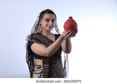 Young Rural Indian Bald Widow Saving Money Holding A Piggy Bank And Wearing A Saree Portraying Various Expressions Of The Widow Life. She Is Confident And Portraying Savings Concept.