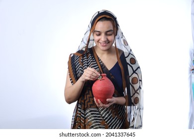 Young Rural Indian Bald Widow Saving Money Inserting A Coin In Piggy Bank, Wearing A Saree Portraying Various Expressions Of The Widow Life. She Is Confident And Portraying Savings Concept.