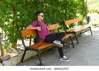 Young Russian Man With Cup Of Coffee Resting On A Bench