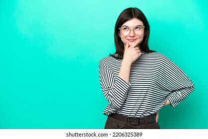 Young Russian Woman Isolated On Green Background Thinking An Idea While Looking Up