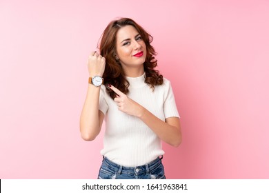 Young Russian Woman Over Isolated Pink Background Showing The Hand Watch