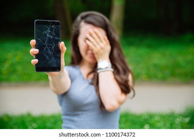 Young Sad Adult Woman Showing Cracked Phone