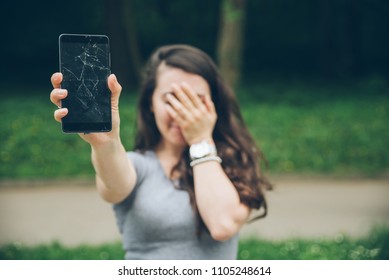 Young Sad Adult Woman Showing Cracked Phone