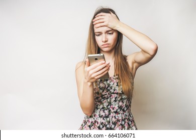 Young sad angry woman with headache and smartphone
