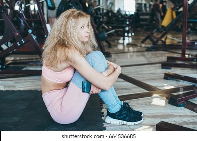 Young Sad Beautiful Girl Sits On The Floor In The Gym And Waits