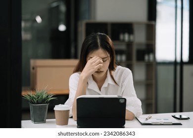 Young sad businesswoman is sitting at table, covering his face. On desk is laptop, tablet computer, Stres from working - Shutterstock ID 2342086343