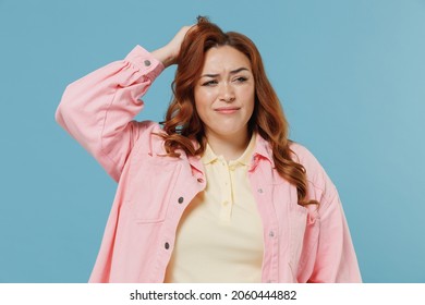 Young Sad Confused Ashamed Redhead Chubby Overweight Woman 30s In Pink Shirt Casual Clothes Scratching Head Look Aside Oops Gesture Isolated On Pastel Blue Background Studio People Lifestyle Concept