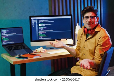 Young Sad Confused Software Engineer IT Programmer Man In Shirt Work At Home Writing Code On Laptop Pc Computer Spread Hands Shrugging Shoulders Look Puzzled Have No Idea Program Development Concept