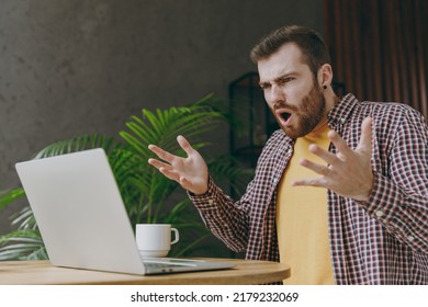 Young Sad Man He Wear Shirt Work Or Study On Laptop Pc Computer Spread Hand Sit Alone At Table In Coffee Shop Cafe Relax Rest In Restaurant In Free Time Indoor Freelance Mobile Office Business Concept