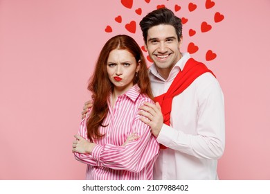 Young Sad Offended Couple Two Friends Woman Man 20s Wear Casual Shirt Trying To Hug Make Up Isolated On Plain Pastel Pink Background Studio Portrait. Valentine's Day Birthday Holiday Party Concept.