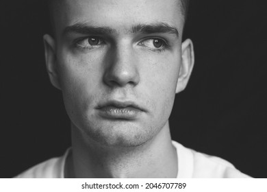 Young Sad Pensive Guy In Depression, Portrait On Black Background.