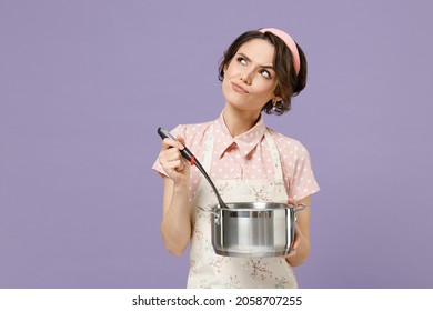 Young Sad Puzzled Confused Housewife Housekeeper Chef Cook Baker Woman In Pink Apron Hold Soup Stainless Pan Saucepan Ladle Look Aside Isolated On Pastel Violet Background Cooking Food Process Concept