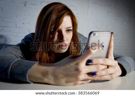 young sad vulnerable girl using mobile phone scared and desperate suffering online abuse cyberbullying being stalked and harassed in teenager cyber bullying concept