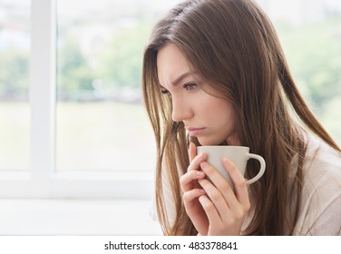 Young Sad Woman With Cup Of Coffee Or Tea. Stress, Depression, Illness Concept.